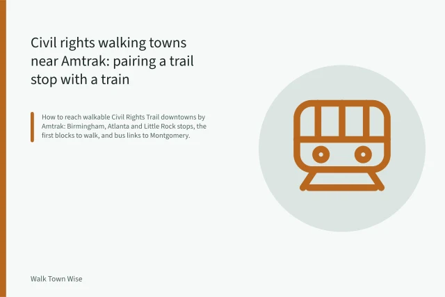 Amtrak train stopped at a downtown station platform beside the tracks. Civil rights walking towns near Amtrak: pairing a trail stop with a train