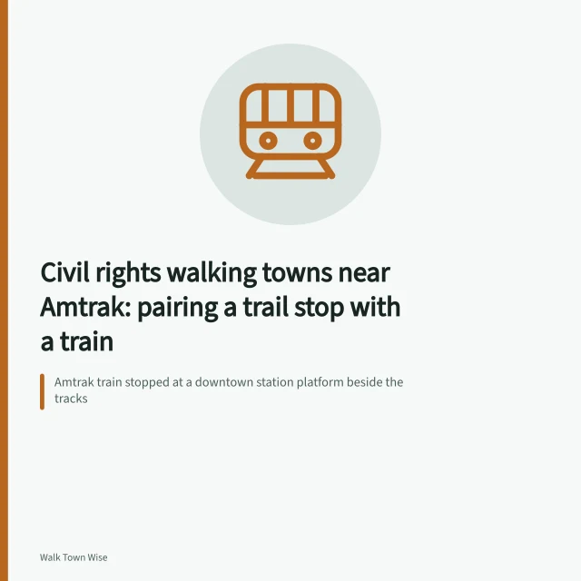 Amtrak train stopped at a downtown station platform beside the tracks. Civil rights walking towns near Amtrak: pairing a trail stop with a train