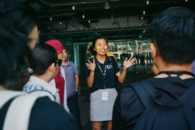 Tour guide leading a group tour, engaging visitors with gestures in an outdoor urban setting. What to ask a local guide before a walkable town trip